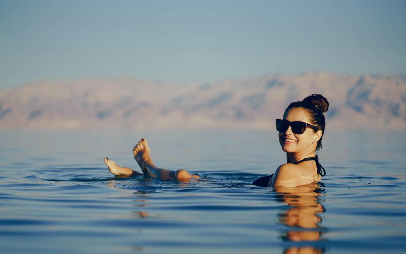brunette girl swimming in the dead sea in israel