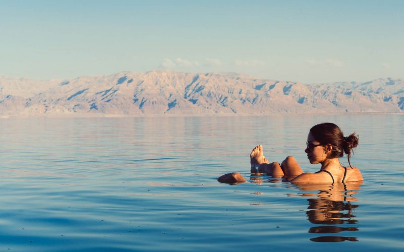 Girl is relaxing and swimming in the water of the Dead Sea in Israel